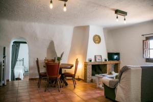 Una sala de estar con una mesa y una chimenea. en Casas Cueva Molino Fuencaliente, en Huéscar