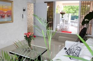 a living room with a vase of flowers on a table at Fully Equipped New 3br Apt dt 2mins To The Beach in Sosúa