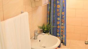 a bathroom with a sink and a shower curtain at Fully Equipped New 3br Apt dt 2mins To The Beach in Sosúa +6 photos