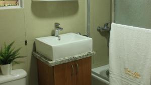 a bathroom with a white sink and a toilet at Fully Equipped New 3br Apt dt 2mins To The Beach in Sosúa +6 photos