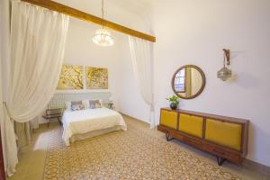 a room with a bed, a mirror, and a dresser at Aminta Home in Las Palmas de Gran Canaria