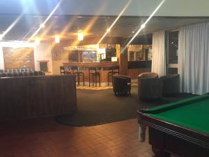 a room with a pool table and a bar at Emerald Central Hotel Official in Emerald