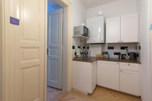 une cuisine avec des placards blancs et une porte blanche dans l'établissement Great place near city centre, à Prague