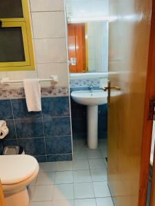 a bathroom with a sink and a toilet and a mirror at Florida City Hotel Apartments (Previously Flora Hotel Apartments) in Dubai