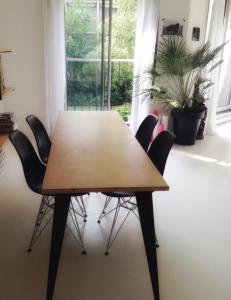 a wooden table with black chairs in a room at Havre de paix en plein Paris in Paris