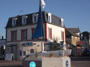a building with a flag in front of a street at résidence de la plage in Jullouville-les-Pins