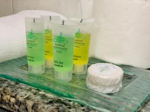 a table with four bottles of soap and a cake at Florida City Hotel Apartments (Previously Flora Hotel Apartments) in Dubai