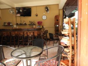 einen Tisch und Stühle in einem Zimmer mit Bar in der Unterkunft P'LYN HOUSE in Chiang Mai