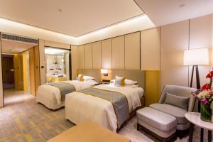 a hotel room with two beds and a chair at Howard Johnson Glory Plaza Chenghai in Shantou +80 photos