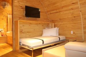 a bedroom with a bed and a tv in a cabin at Vida Loca Sunset Beach Resort in Phu Quoc
