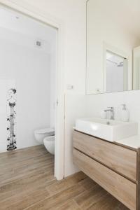 a white bathroom with a sink and a mirror at MI HOME NAVIGLI in Milan