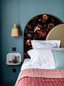 una camera con un grande letto con una parete blu di Hôtel Léopold - Orso Hotels a Parigi