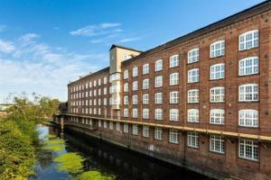a large brick building next to a river at I Should Cocoa (York) - Joseph in York