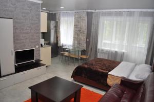 a bedroom with a bed and a tv and a table at Apartments in the heart of Kursk on Radischeva street in Kursk