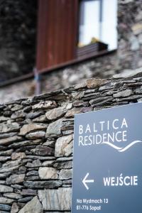 a sign on the side of a stone wall at Baltica Residence in Sopot