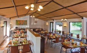 a restaurant with tables and chairs in a room at Club Mahindra Sasan Gir in Sasan Gir