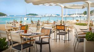 a restaurant with tables and chairs and the ocean at Maistra Select Belvedere Resort in Vrsar