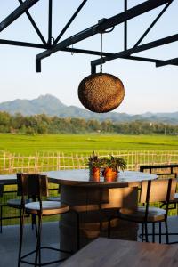 a table and chairs with a view of a field at SuanGlangNa in Phrae
