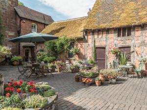 une cour avec des pots de fleurs et un parasol dans l'établissement Housekeeper's Cottage, à Great Bolas
