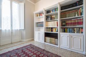 a library with white book shelves filled with books at Santa Maria Novella 4 bedrooms in Florence