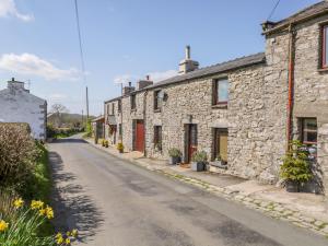 une rue vide dans un village avec des maisons en pierre dans l'établissement Rosemary Cottage, à Carnforth
