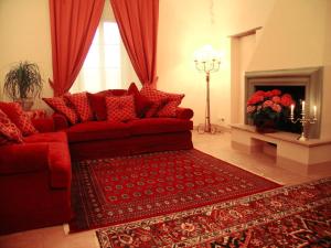 a living room with a red couch and a fireplace at Residenza Antica Canonica in Casole dʼElsa