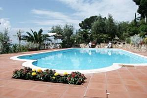 een groot zwembad in een tuin met bloemen bij Lovely place in Passignano sul Trasimeno
