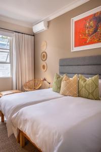 a bedroom with a large white bed and a window at Antrim Villa Guesthouse in Cape Town