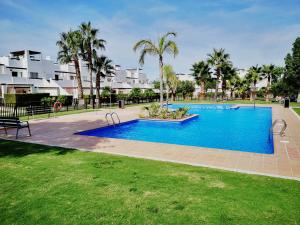 einen Pool in einem Park mit Palmen in der Unterkunft 2 Bedroom Apartment Condado de Alhama in Alhama de Murcia