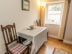 a table and a chair in a room with a window at Kirk Cottage in Hownam +18 photos