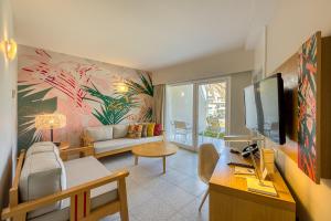 een woonkamer met een bank en een tv bij Hotel LIVVO Koala Garden in Maspalomas