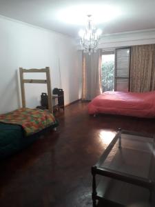 a room with two beds and a chandelier at Hombres Negociadores, Artistas Huéspedes Especiales in Rosario