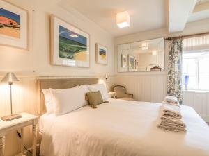 une chambre avec un grand lit blanc et une fenêtre dans l'établissement Housekeeper's Cottage, à Great Bolas