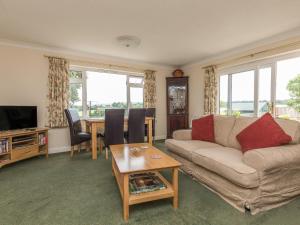 a living room with a couch and a table at Pipistrelle Lodge in Plymtree