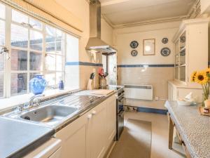 une cuisine avec un évier et une fenêtre dans l'établissement Housekeeper's Cottage, à Great Bolas 14 autres photos