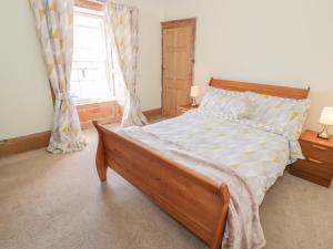 a bedroom with a large bed and a window at The Pink House in Isle of Whithorn