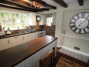 a kitchen with a large clock on the wall at Stallington Hall Farm in Fulford