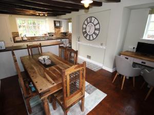 a dining room with a wooden table and a clock on the wall at Stallington Hall Farm in Fulford