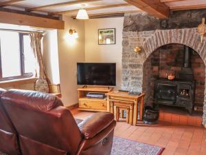 a living room with a leather couch and a fireplace at Tuc - Tin in Clun