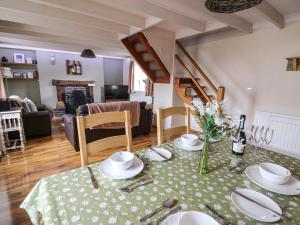 a living room with a table with a green table cloth at Cozy Cwtch Cottage in Llangynllo