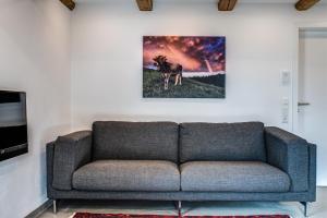 a living room with a couch and a painting on the wall at Ferienhaus Tor zum Allgäu in Vogt