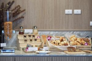 a buffet with different types of bread and pastries at Eleven Hotel Bangkok Sukhumvit 11 in Bangkok