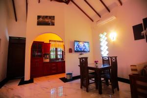 a dining room with a table and a tv at SRI LANKAN VILLA in Galle