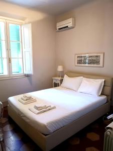 ein Schlafzimmer mit einem weißen Bett mit zwei Handtüchern darauf in der Unterkunft Lanfranchi deluxe apartament in Pisa