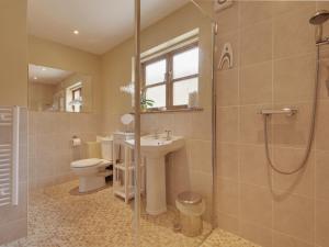 y baño con aseo, lavabo y ducha. en 2 Shippen Cottages en Cotleigh