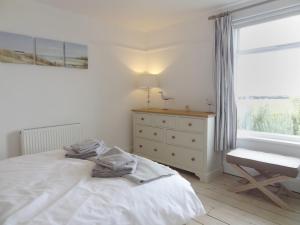 a bedroom with a bed and a dresser and a window at Ley Park in Welcombe