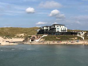 a building on a hill next to a beach at Chapel Rock View, The Dunes in Perranporth