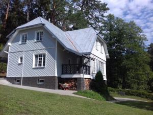 ein weißes Haus mit einem Gameradach in der Unterkunft Mizarai Mill House in Druskininkai