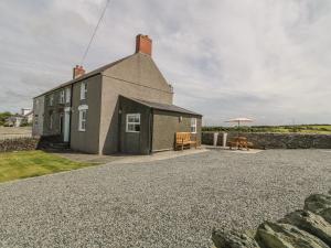 a house with a gravel driveway in front of it at Glasfryn in Holyhead