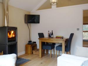 a living room with a table and a fireplace at Rock View Cottage in Gunnislake